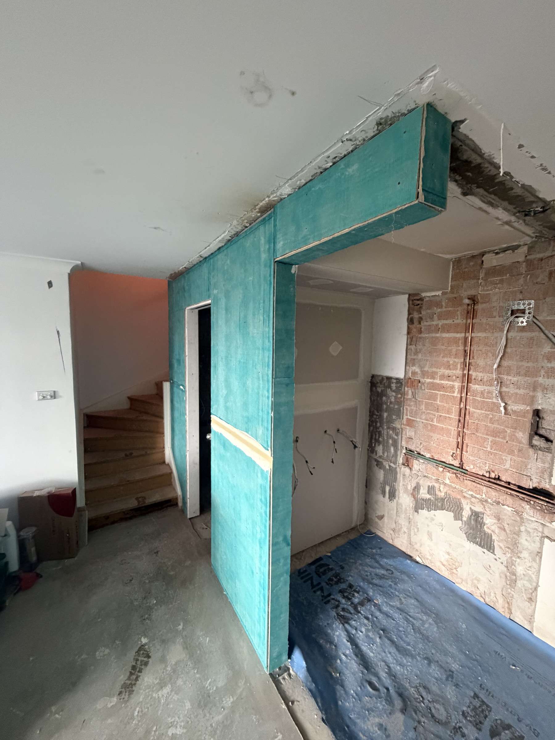 Neutral Bay during construction, a new framed wall beside the stair and brick exposed behind