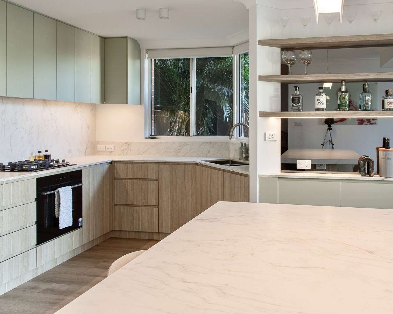 Neutral Bay kitchen with sage cabinets, marble benchtops and open shelves